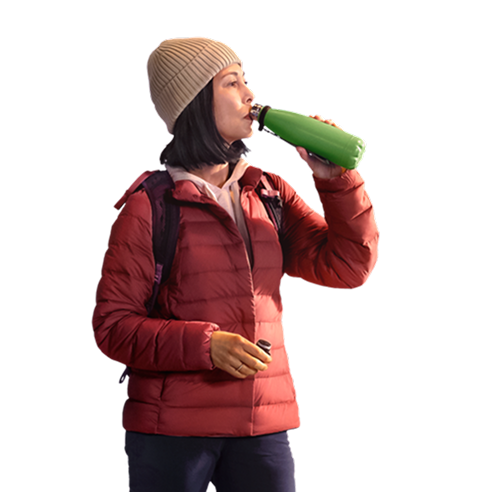 Woman on a hike drinking from a water bottle