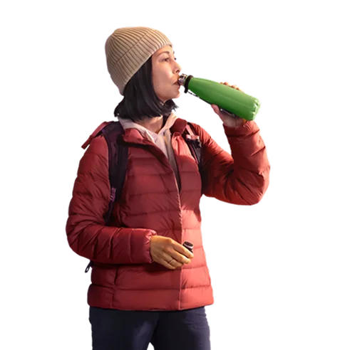 Woman on a hike drinking from a water bottle